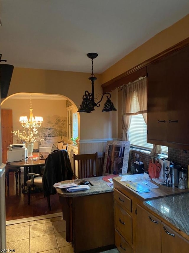 tiled dining area featuring a chandelier