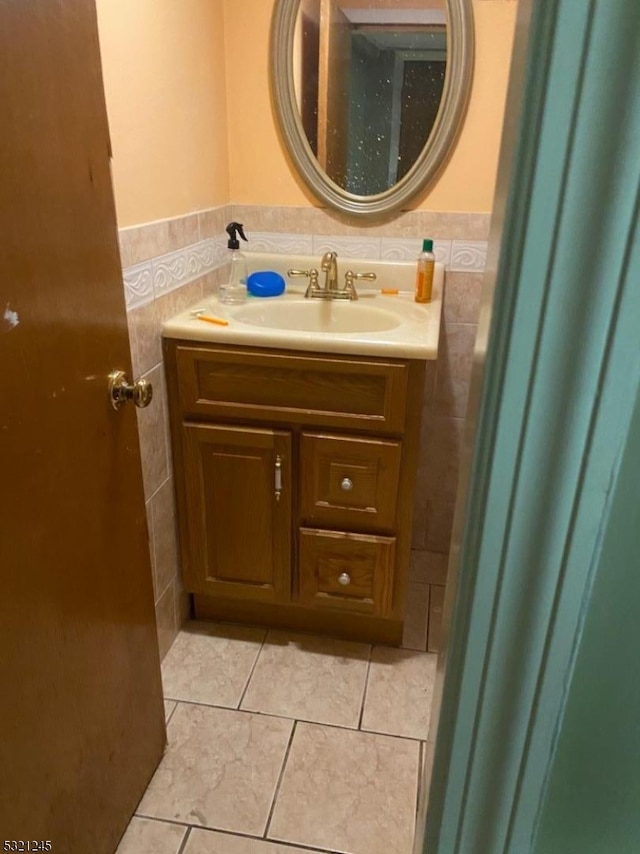 bathroom with tile patterned flooring, vanity, and tile walls