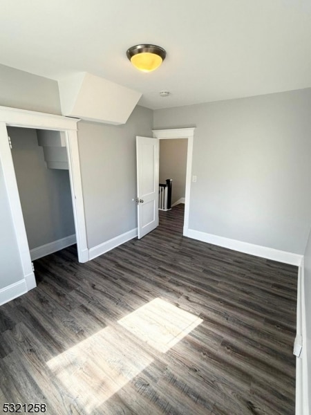 unfurnished bedroom featuring a closet and dark hardwood / wood-style flooring