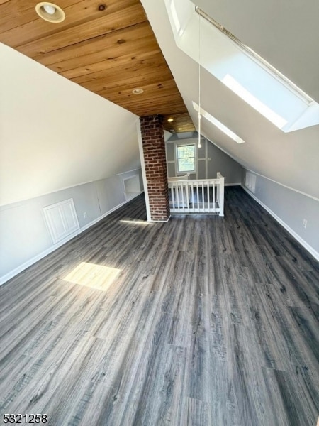 bonus room featuring wood ceiling, lofted ceiling with skylight, and dark hardwood / wood-style flooring