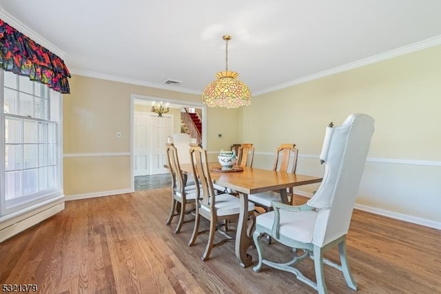 dining room featuring crown molding and hardwood / wood-style flooring