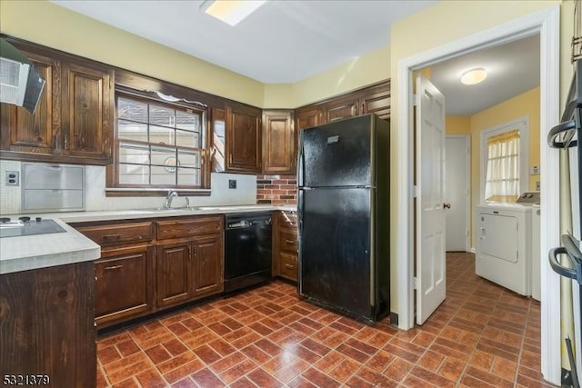 kitchen with black appliances, decorative backsplash, sink, dark brown cabinetry, and separate washer and dryer