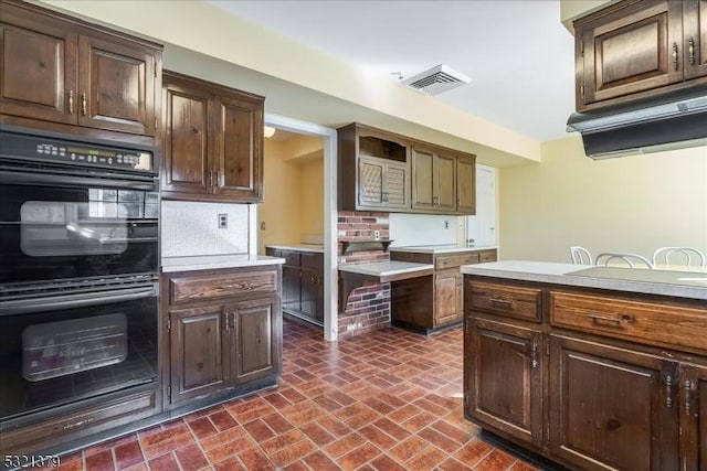 kitchen featuring double oven, decorative backsplash, and dark brown cabinetry