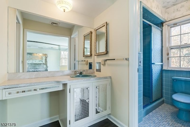 bathroom featuring vanity, toilet, tile walls, and walk in shower