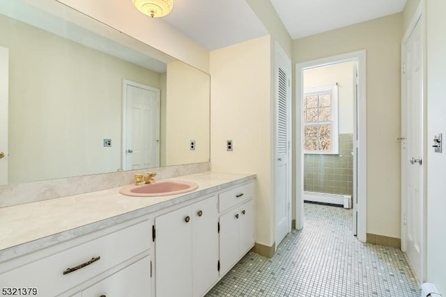 bathroom with a baseboard heating unit, tile patterned flooring, and vanity