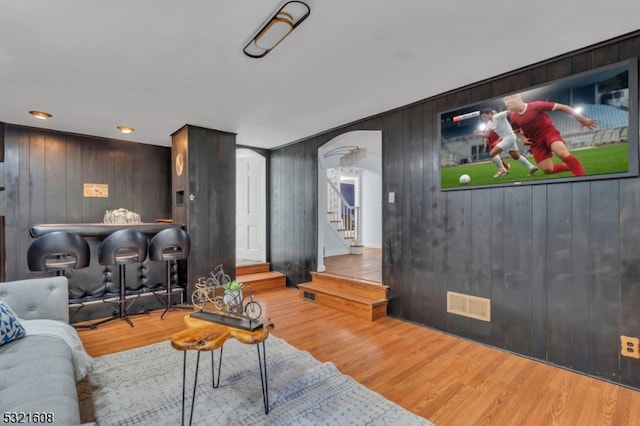 living room with hardwood / wood-style flooring and wooden walls