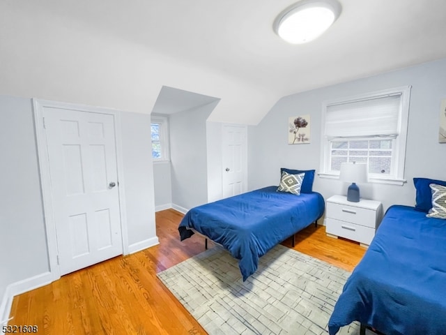 bedroom featuring vaulted ceiling and light hardwood / wood-style flooring