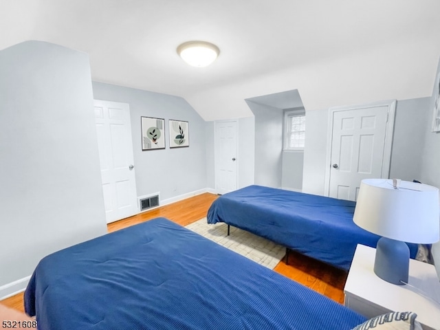 bedroom featuring lofted ceiling and hardwood / wood-style flooring