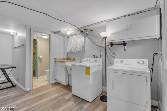 laundry room with washer and clothes dryer and light hardwood / wood-style floors