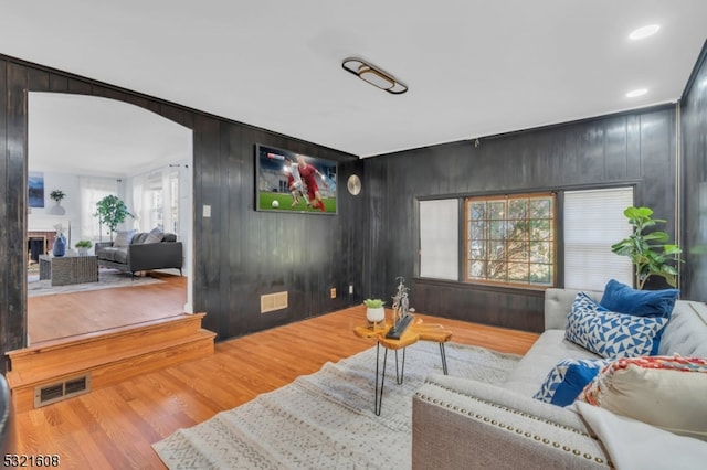 living room with plenty of natural light, hardwood / wood-style floors, and wooden walls