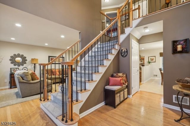 stairs featuring hardwood / wood-style flooring and a high ceiling