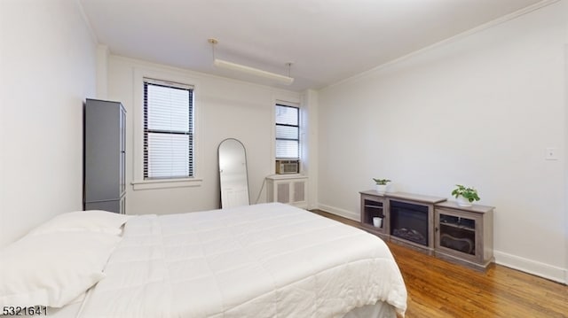 bedroom with ornamental molding and hardwood / wood-style flooring