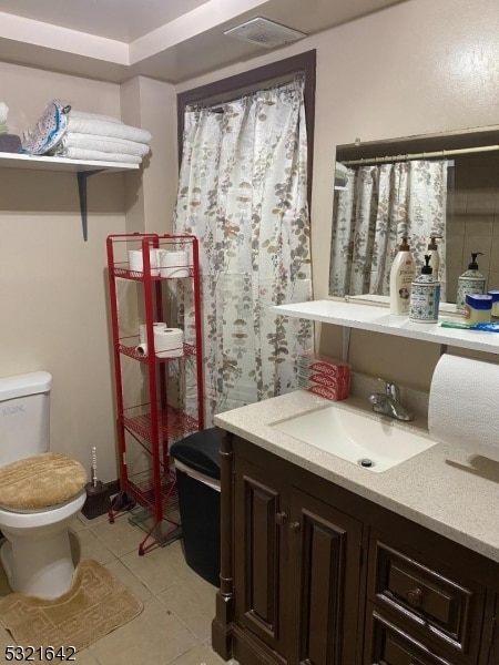 bathroom featuring tile patterned flooring, vanity, and toilet