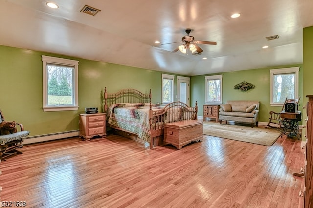 bedroom with light hardwood / wood-style floors, ceiling fan, vaulted ceiling, and a baseboard heating unit