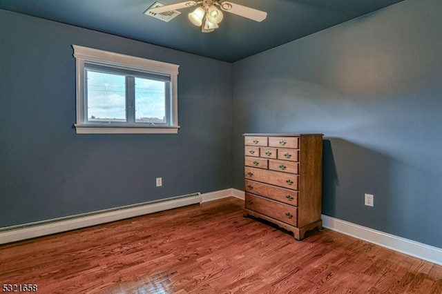 unfurnished bedroom featuring ceiling fan, hardwood / wood-style flooring, and baseboard heating