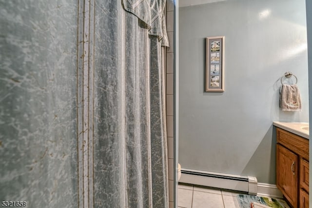 bathroom with tile patterned floors, walk in shower, vanity, a baseboard heating unit, and toilet