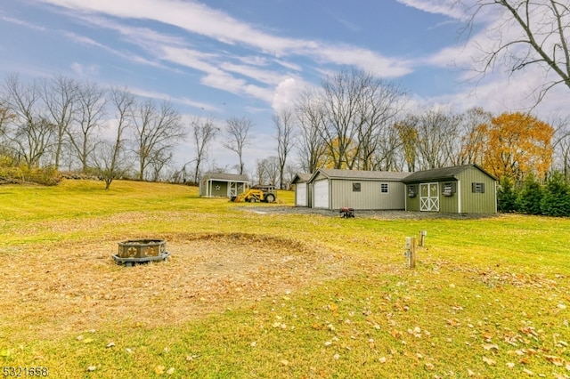 view of yard with an outbuilding and a fire pit