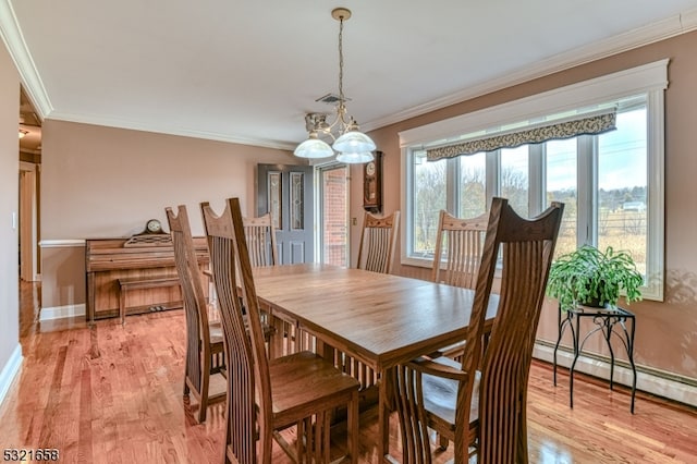 dining area featuring light hardwood / wood-style floors, a chandelier, baseboard heating, and ornamental molding