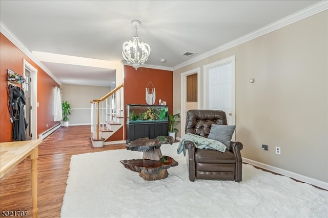 sitting room featuring baseboard heating, crown molding, a notable chandelier, and hardwood / wood-style flooring