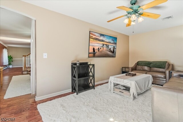 living room with dark hardwood / wood-style floors and ceiling fan