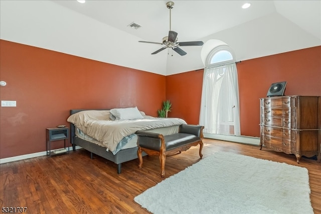 bedroom featuring dark hardwood / wood-style flooring, baseboard heating, vaulted ceiling, and ceiling fan