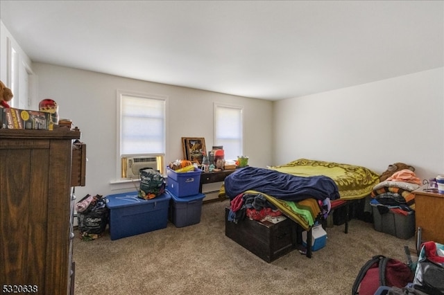 bedroom with cooling unit and light colored carpet