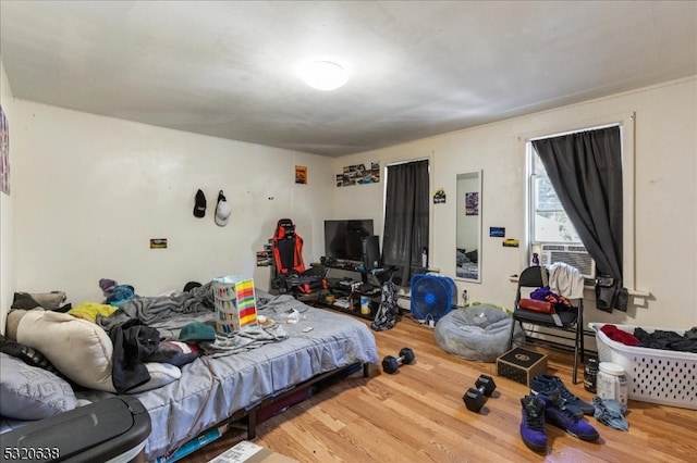 bedroom with cooling unit and wood-type flooring