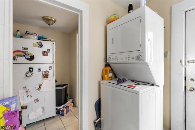 laundry area with light tile patterned floors and stacked washer and clothes dryer