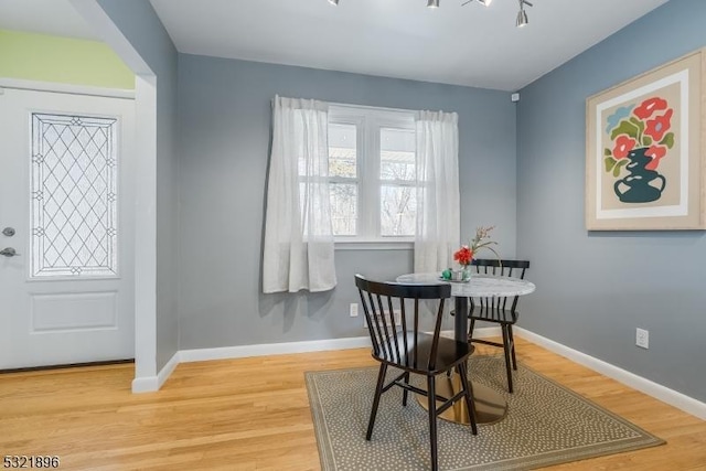 dining area with baseboards and wood finished floors