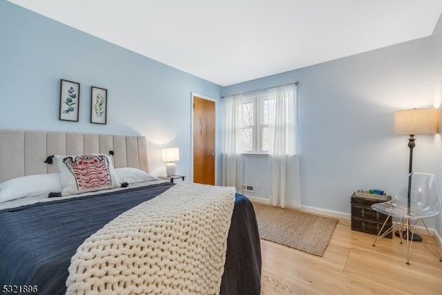 bedroom with baseboards and wood finished floors