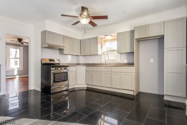 kitchen featuring gas range, dark tile patterned floors, a baseboard heating unit, sink, and gray cabinets