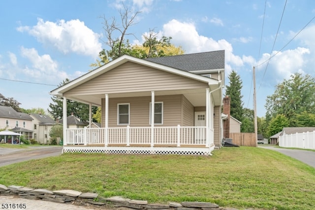 bungalow featuring covered porch and a front lawn