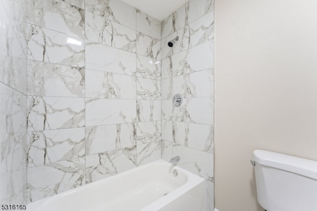 bathroom featuring tiled shower / bath combo and toilet