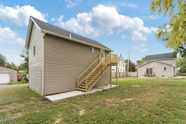 back of property with a garage, a deck, and a lawn