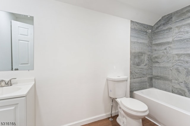 full bathroom featuring toilet, tiled shower / bath, hardwood / wood-style flooring, and vanity