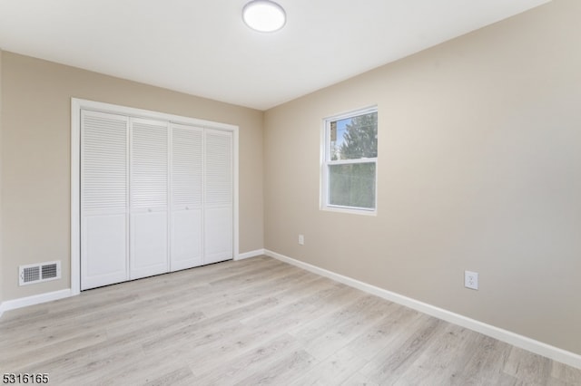 unfurnished bedroom featuring a closet and light hardwood / wood-style floors