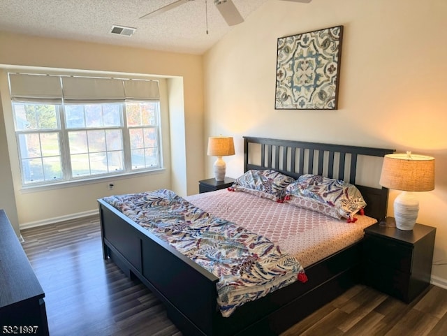 bedroom featuring ceiling fan, dark hardwood / wood-style floors, and a textured ceiling