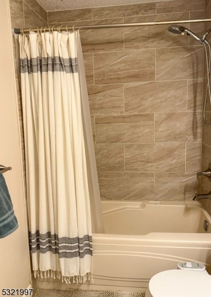 bathroom featuring toilet and shower / bath combo