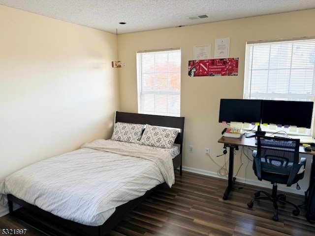 bedroom featuring a textured ceiling and dark hardwood / wood-style flooring