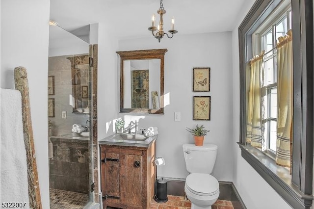 bathroom featuring an enclosed shower, vanity, toilet, and an inviting chandelier