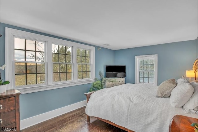 bedroom with dark hardwood / wood-style flooring