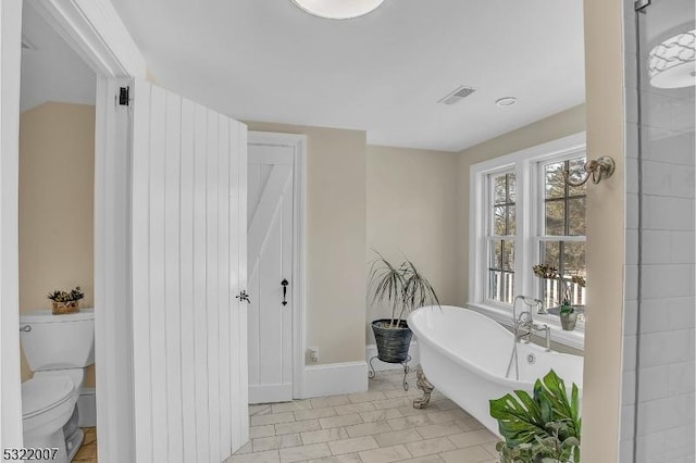 bathroom with toilet and a washtub