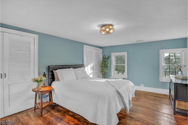 bedroom featuring dark hardwood / wood-style floors and multiple windows