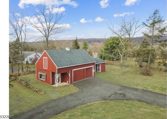 view of outbuilding featuring a garage and a lawn