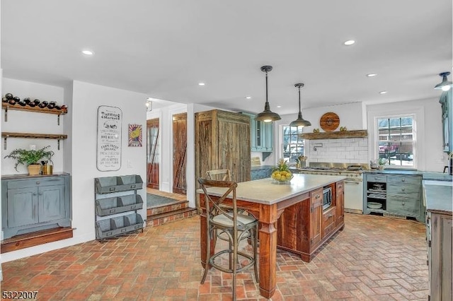 kitchen with sink, hanging light fixtures, backsplash, and a center island