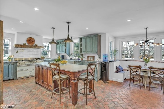 kitchen featuring pendant lighting, green cabinetry, backsplash, a kitchen bar, and kitchen peninsula