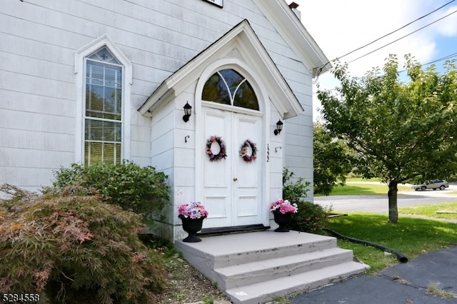 property entrance with a lawn