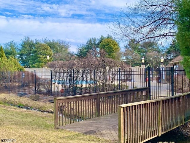 wooden terrace with a yard and fence