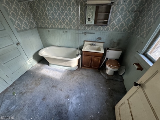 bathroom featuring a washtub, vanity, and toilet