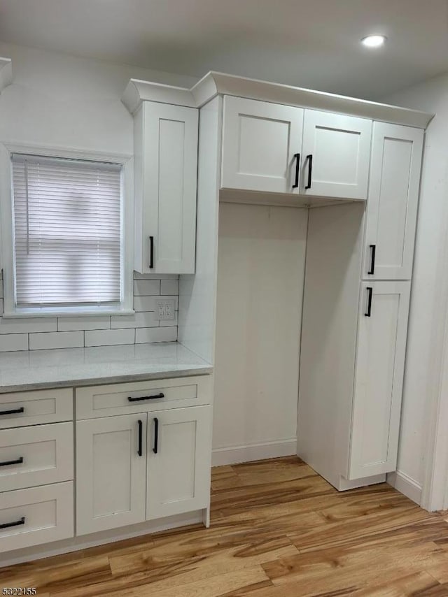 kitchen featuring tasteful backsplash, recessed lighting, light wood-style floors, white cabinets, and baseboards